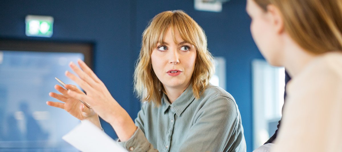 Businesswoman sharing ideas with colleague in meeting